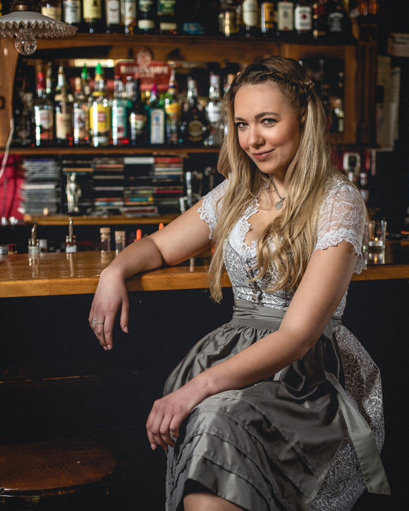 FAHTPIX-Frau_sitzt_an_Bar_lächelt