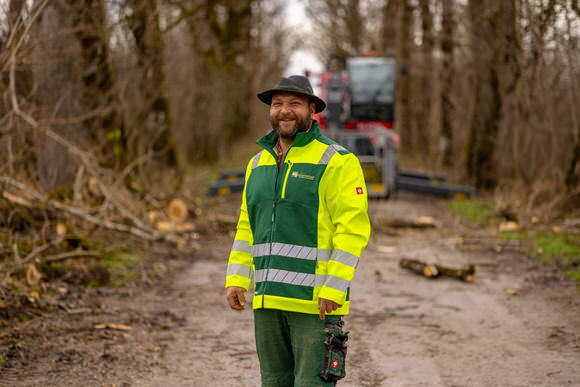 FAHTPIX-Mann_in_Warnjacke_vor_Baumstämmen